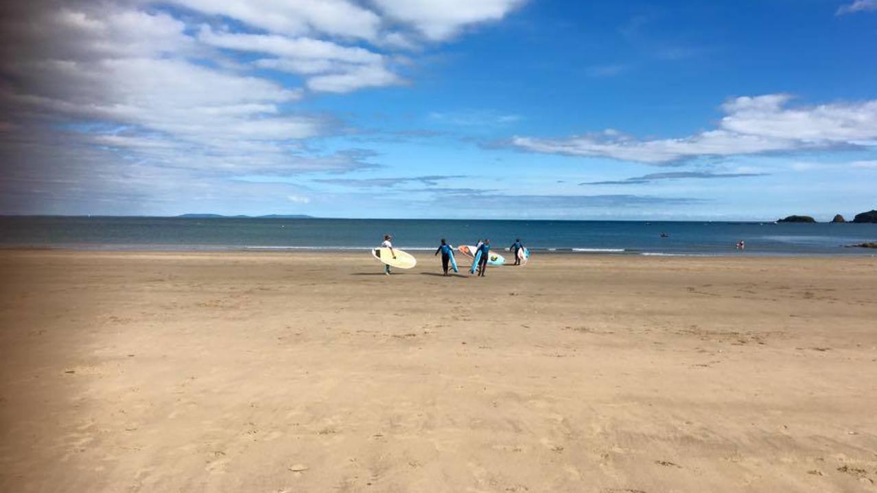 People surfing on beach at Good Trails in Saundersfoot
