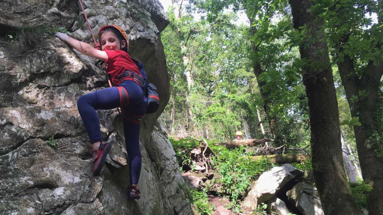 A young girl climbs a rock face at Adventure Beyond in LLandysul A young girl climbs a rock face at Adventure Beyond in LLandysul