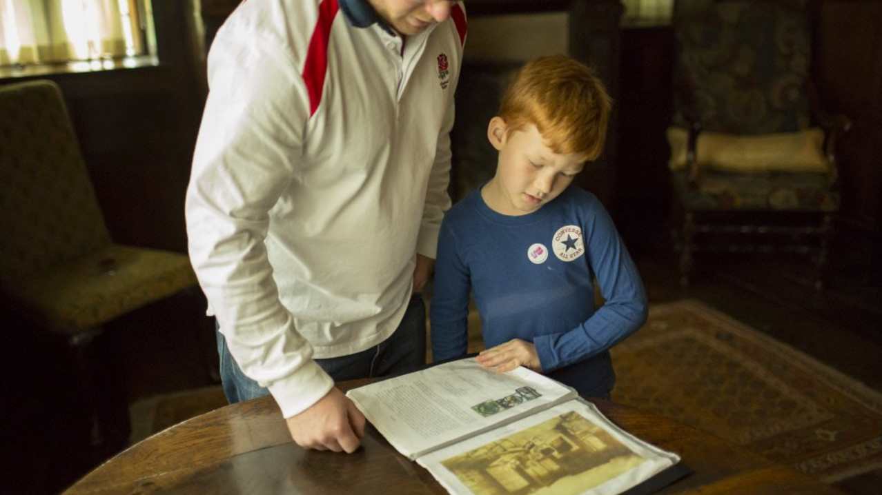 Man and little boy looking at a leaflet at Packwood House Man and little boy looking at a leaflet at Packwood House