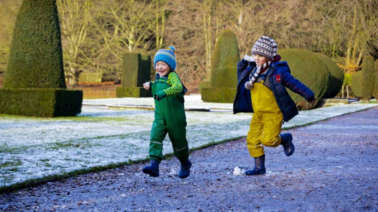 Children playing in the garden in winter at Sudbury Hall, Derbyshire