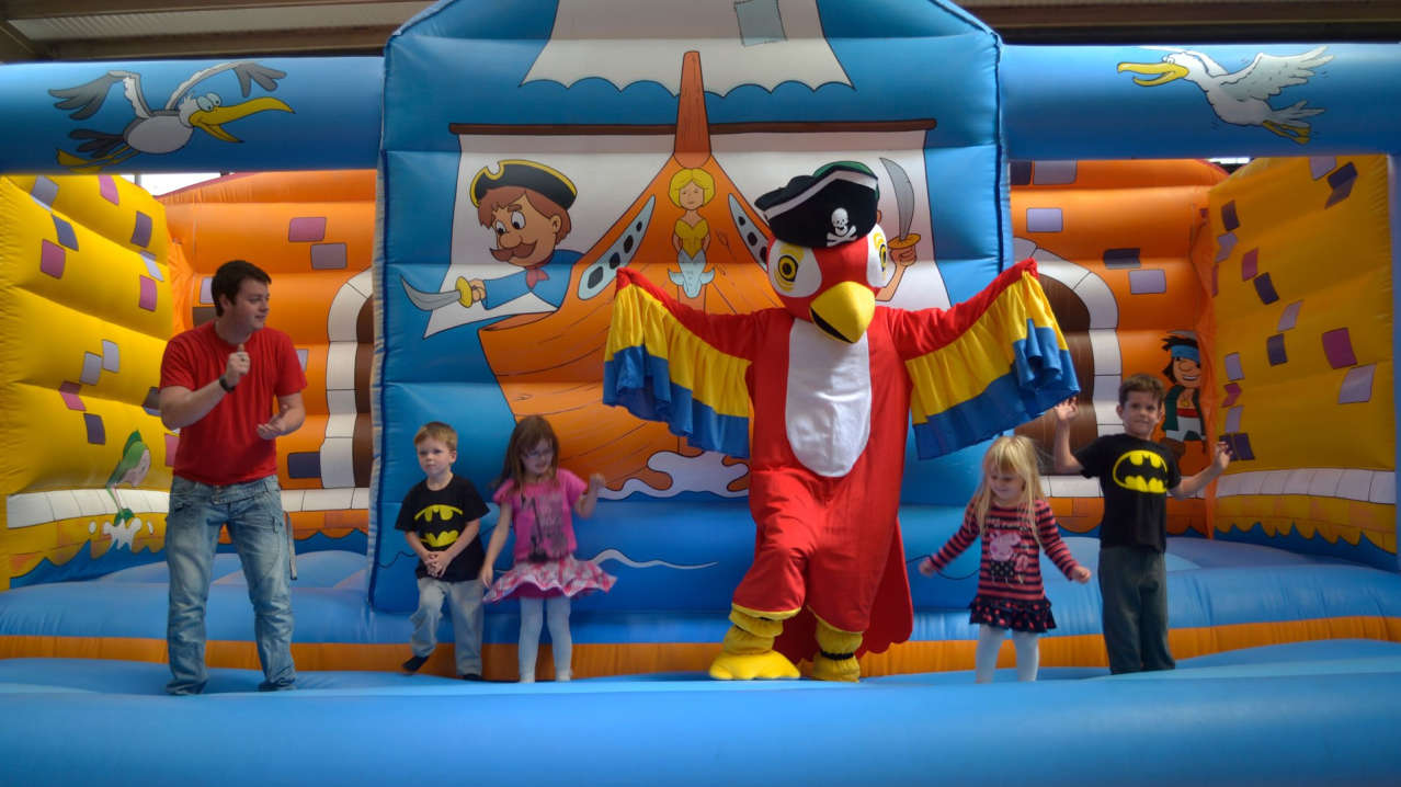 Bird mascot on bouncy castle with kids at Jolly Roger Adventure in Swindon