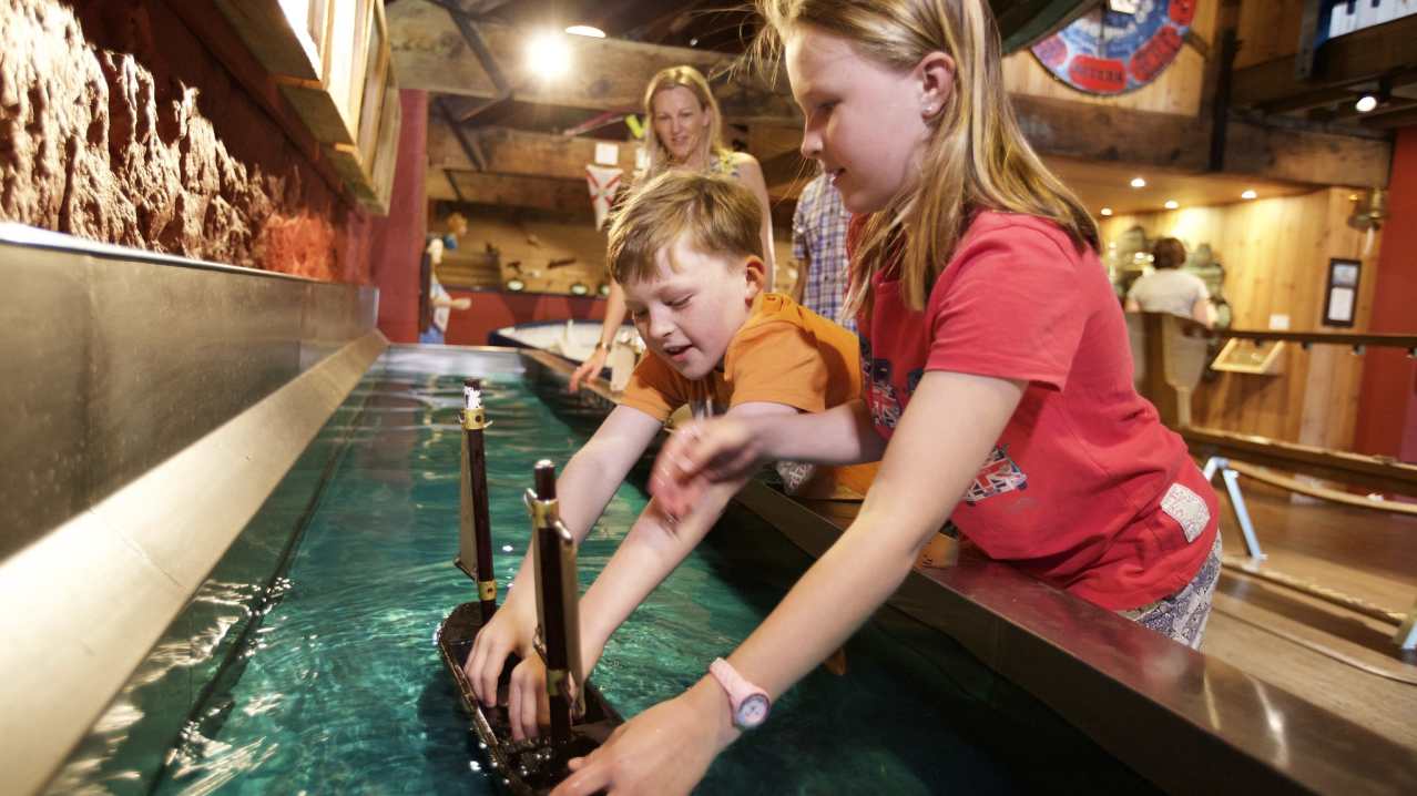 Kids playing with model boat at Maritime Museum in Jersey
