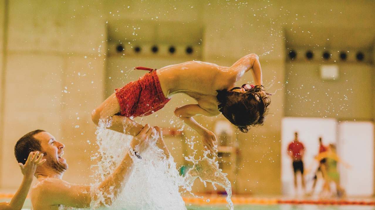 Boy flipping in swimming pool at London Aquatics Centre in London