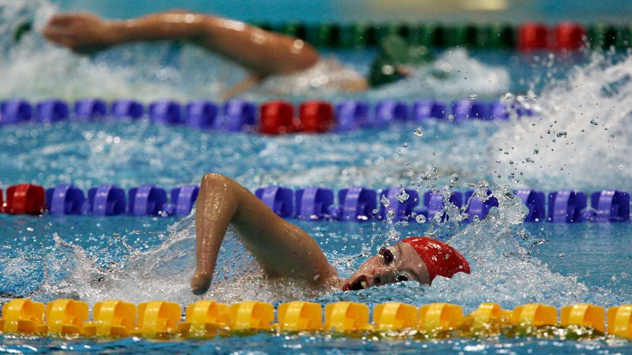 People swimming at London Aquatics Centre