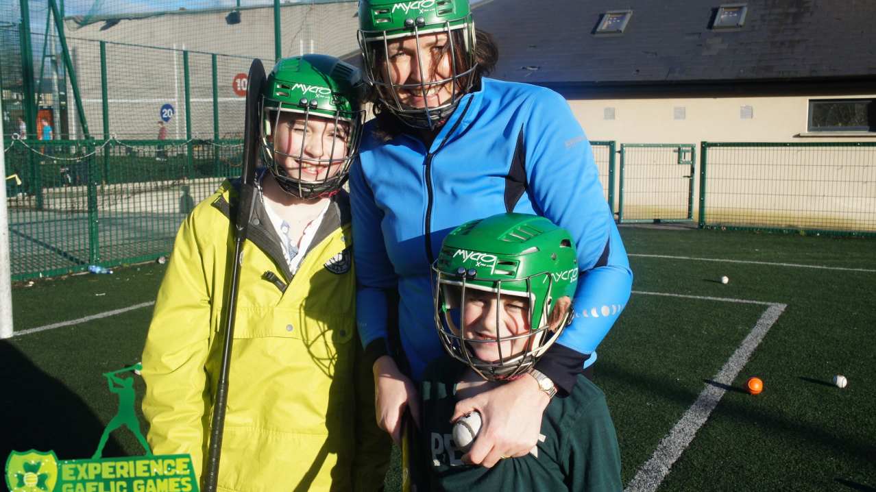 Family playing hockey at Experience Gaelic Games in Dublin Family playing hockey at Experience Gaelic Games in Dublin