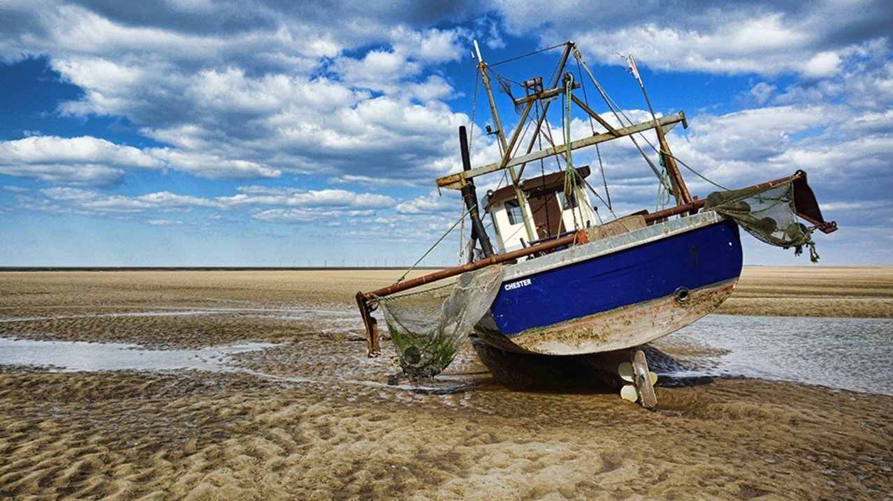 Boat left standing at Meols Beach in Wirral Boat left standing at Meols Beach in Wirral