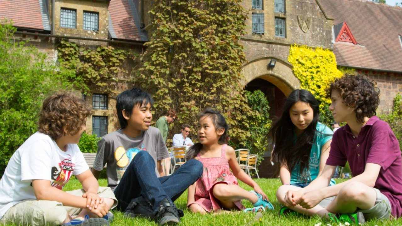 A group of kids sat on the grass at Knightshayes Court, photo credit National Trust/Tony Cobley