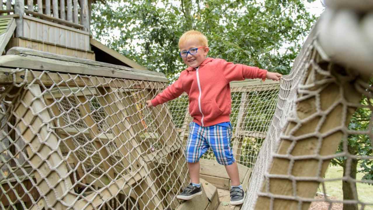 A little boy playing at RHS Hyde Hall gardens in Chelmsford