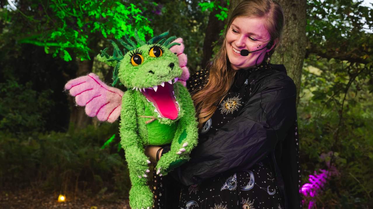 woman holding bewilderwood character woman holding bewilderwood character