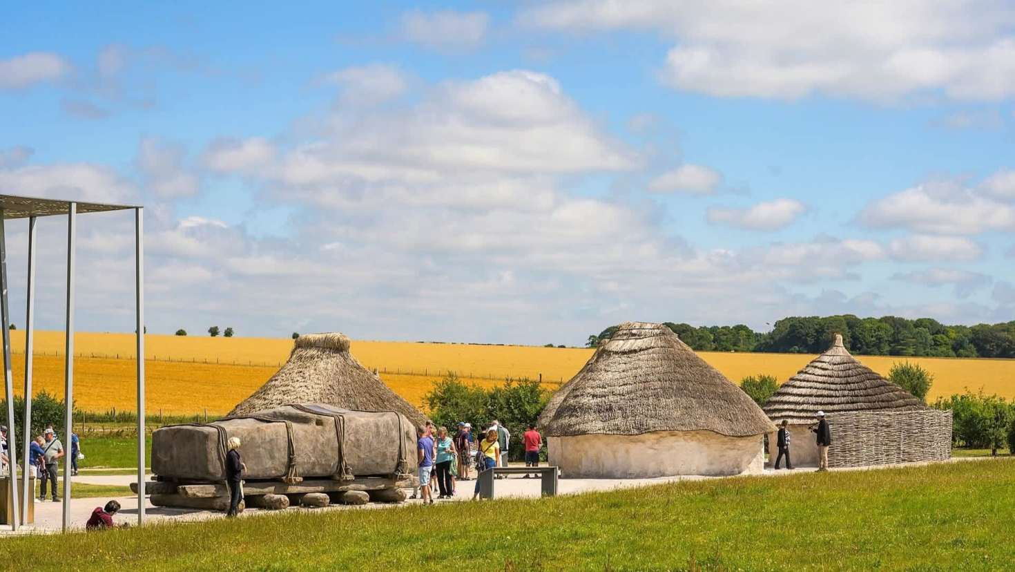 Children exploring the Neolithic houses at Stonehenge, Wiltshire