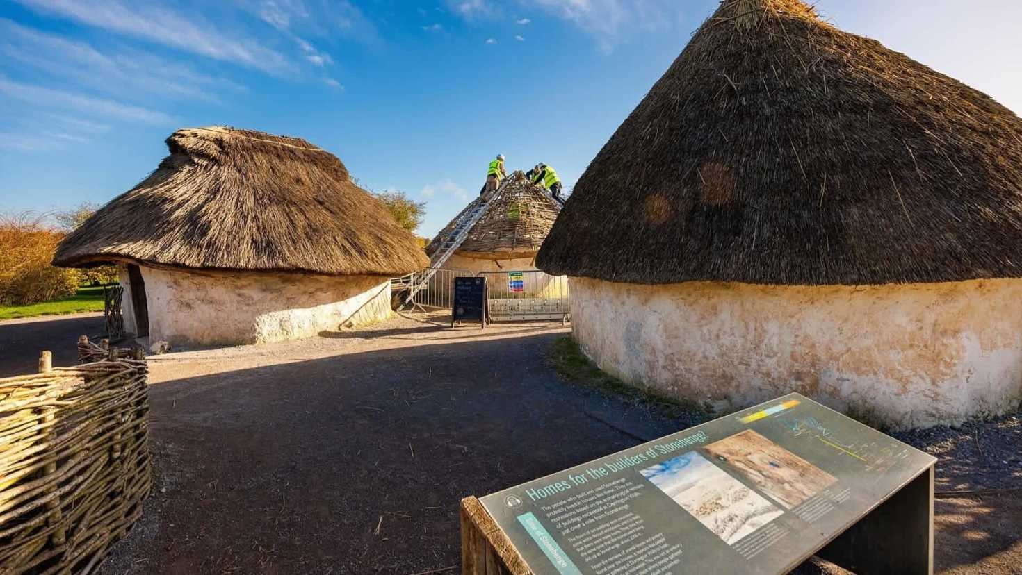 neolithic houses with information board in the forefront