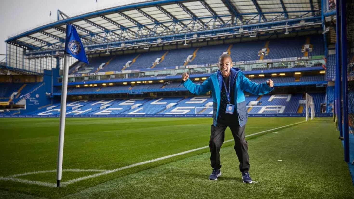 Child celebrating pitchside at Stamford Bridge during the Chelsea FC Stadium Tour experience