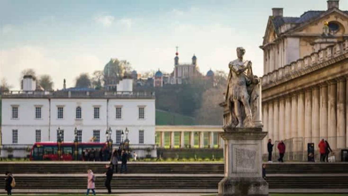 Statue in front of Old Royal Naval College with Royal Observatory Greenwich on the hill in the background Statue in front of Old Royal Naval College with Royal Observatory Greenwich on the hill in the background
