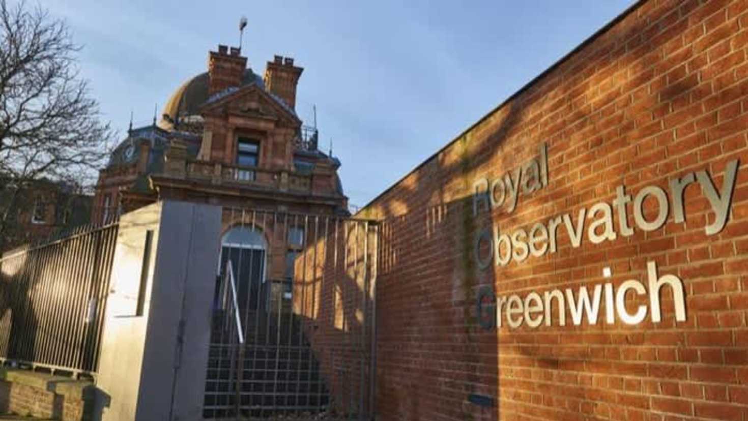 Entrance to Royal Observatory Greenwich with brick wall signage and historic dome building Entrance to Royal Observatory Greenwich with brick wall signage and historic dome building