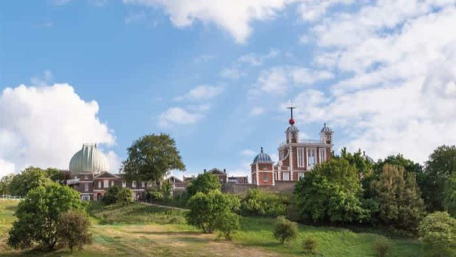 Royal Observatory Greenwich on the hilltop in Greenwich Park with blue sky
