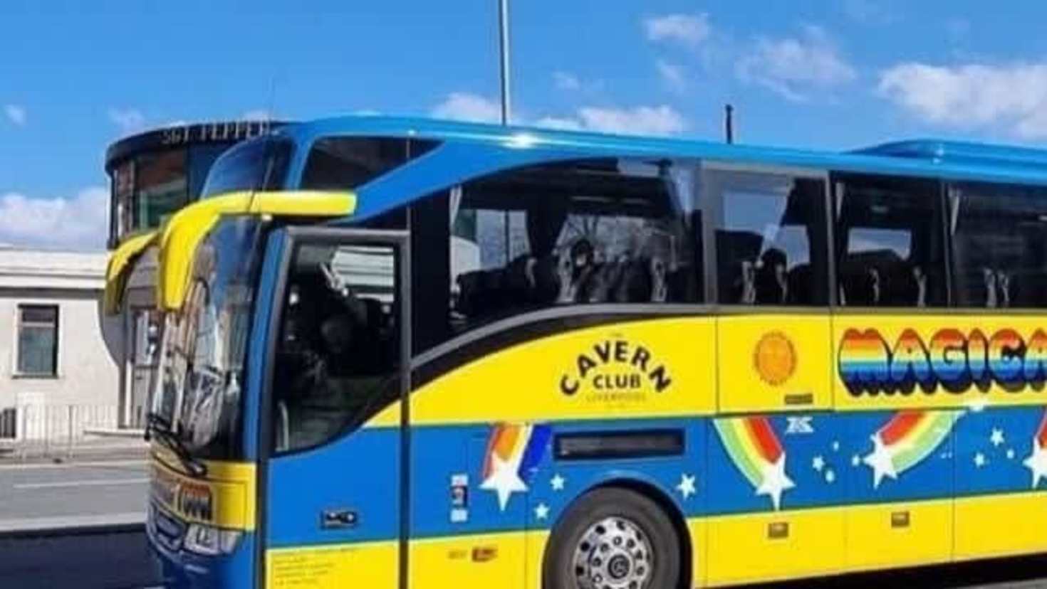 Magical Mystery Tour coach on the road in Liverpool, painted in colourful Beatles design.