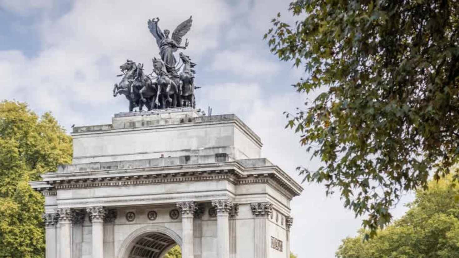 Close-up view of Wellington Arch with quadriga statue framed by trees