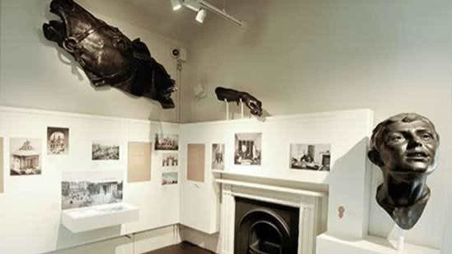Interior exhibition gallery at Wellington Arch featuring historic photographs and bronze sculptures
