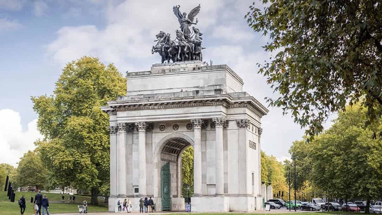 Wellington Arch in London on a sunny day with trees and visitors in the background