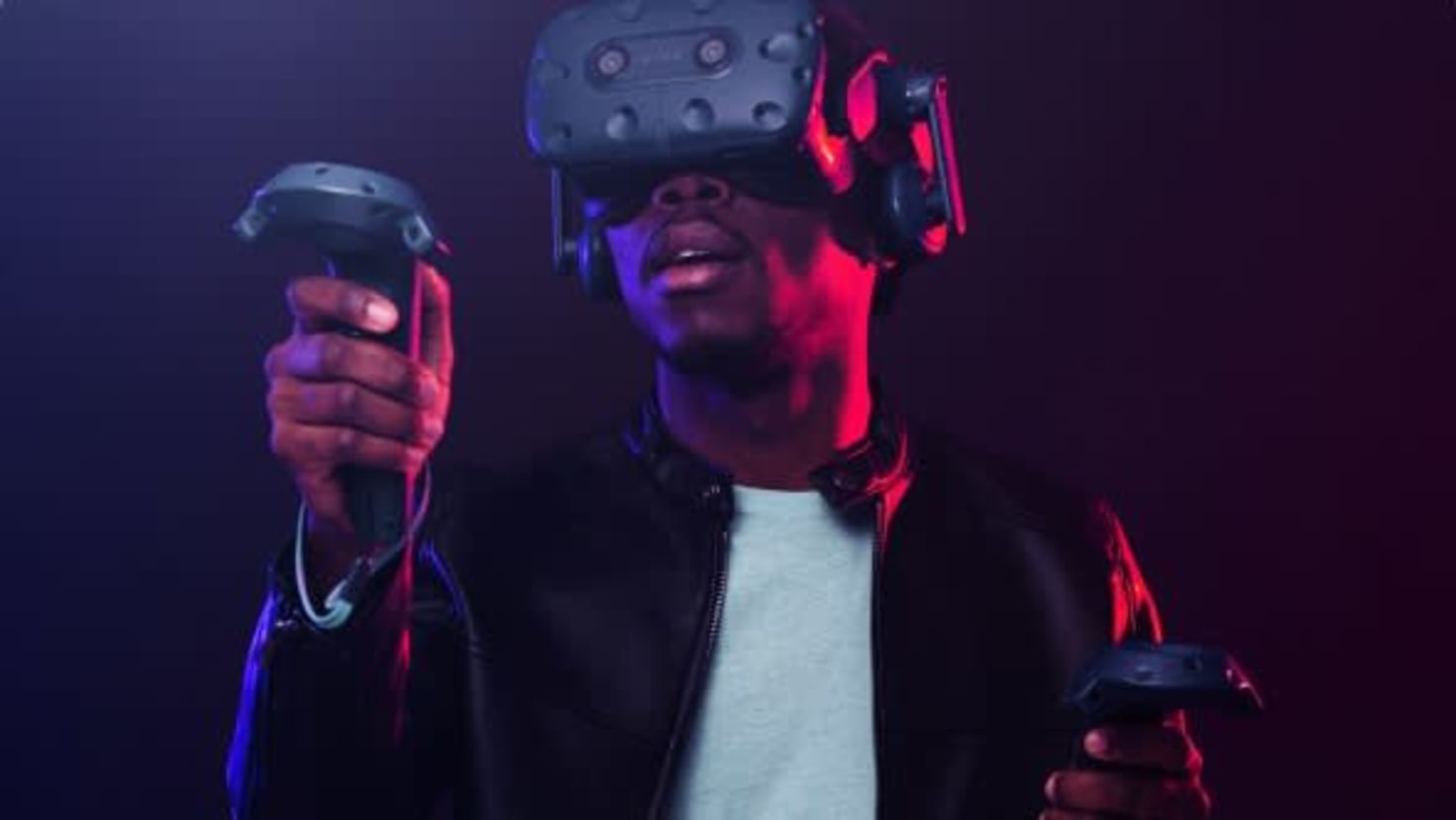Player using VR headset and controllers in a neon‑lit room at DNA VR Camden