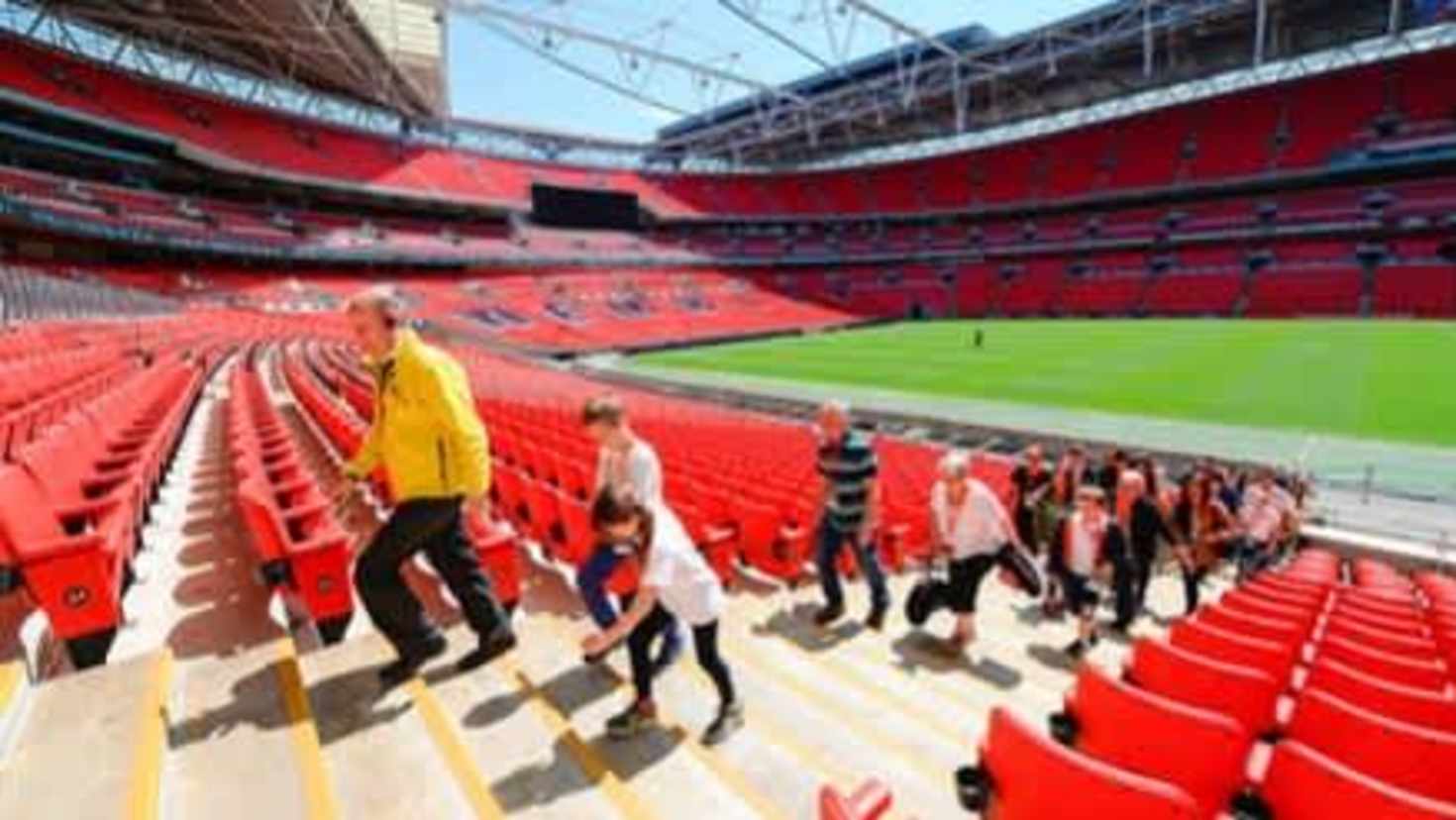 Guided Wembley Stadium tour with visitors walking through the stands