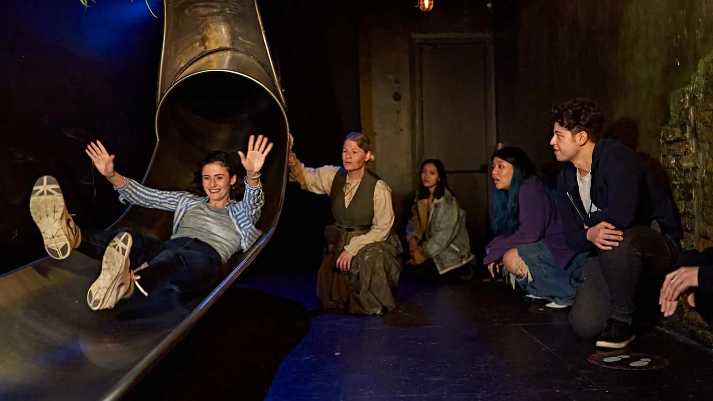 A guest slides into an interactive scene at Jeff Wayne’s War of the Worlds immersive show, an adventure available with Jeff Wayne’s War of the Worlds tickets.