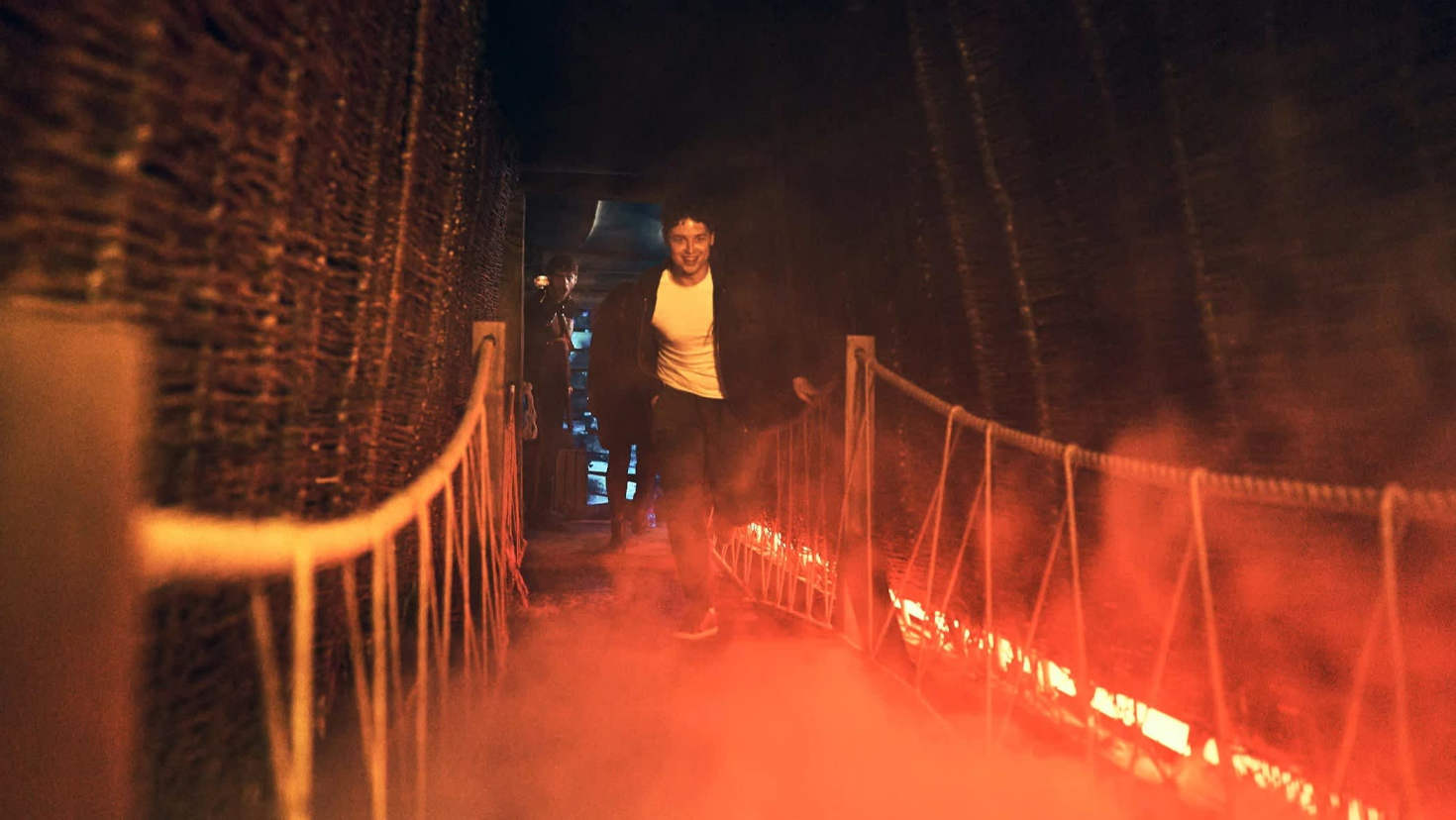 Visitor runs across a smoky rope bridge during Jeff Wayne’s War of the Worlds immersive adventure, included with Jeff Wayne’s War of the Worlds tickets.