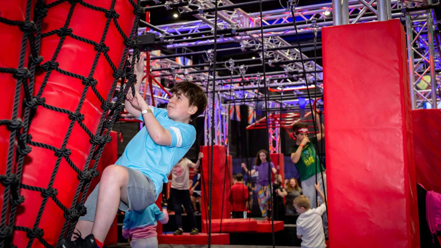 boy climbing obstacle course