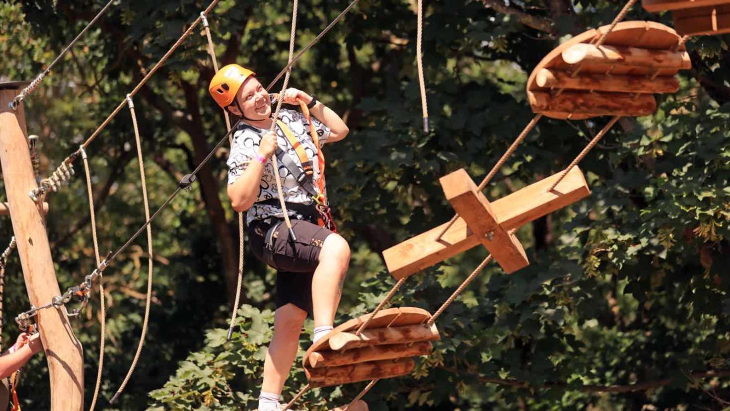 Person tackling the high ropes course at Gripped London adventure park, wearing safety harness and helmet