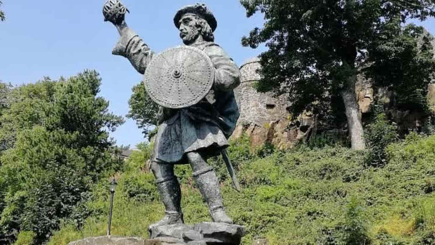 Rob Roy McGregor statue with scenic Highland backdrop