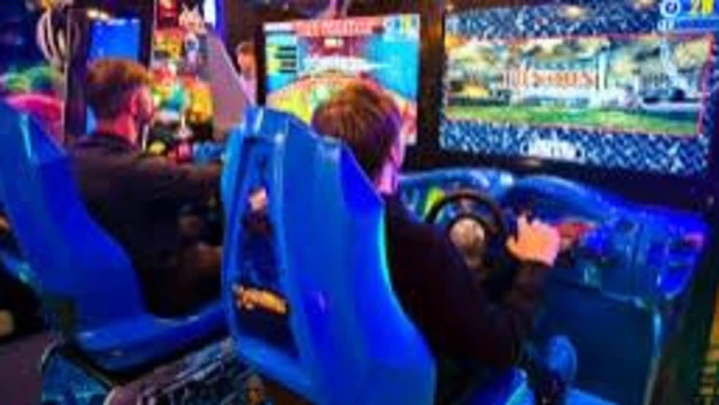 Group of friends playing multiplayer arcade games together Group of friends playing multiplayer arcade games together
