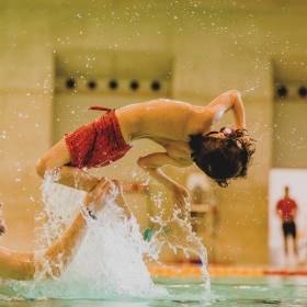 Boy flipping in swimming pool at London Aquatics Centre in London