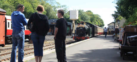 Visitors on platform by trains at Bodmin and Wenford Railway