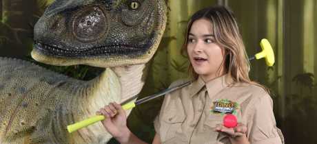 Staff member by dinosaur at Dino Golf in Blackpool
