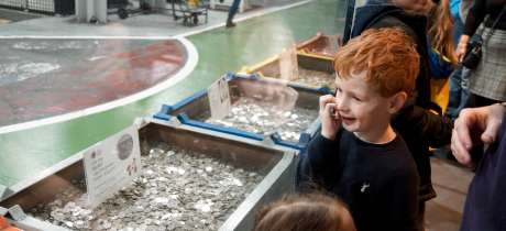 A little boy looking at the exhibitions at The Royal Mint Experience