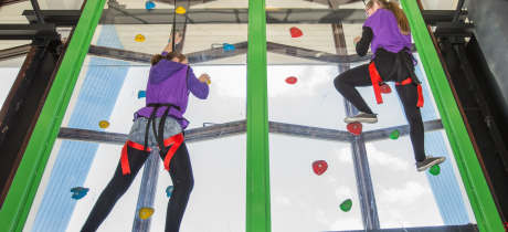 Girls climbing at Clip n Climb Dundonald in Belfast