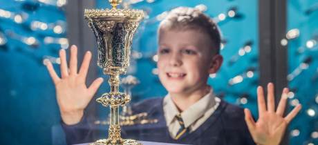 A kid stares and smiles at the King John Cup at Stories of Lynn