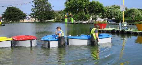 Staff by boats at Onchan Pleasure Park in Onchan
