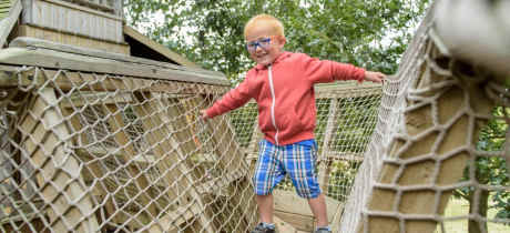A little boy playing at RHS Hyde Hall gardens in Chelmsford
