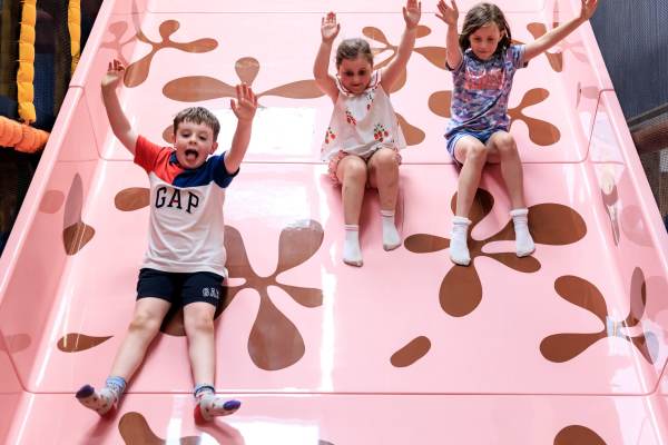 children enjoying large, fast, indoor slide children enjoying large, fast, indoor slide