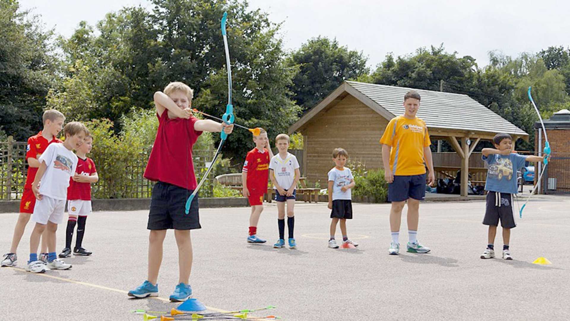 a group of children taking part in an archery class