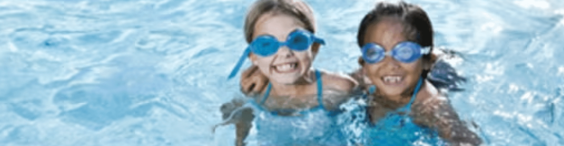 2 children swimming with goggles on