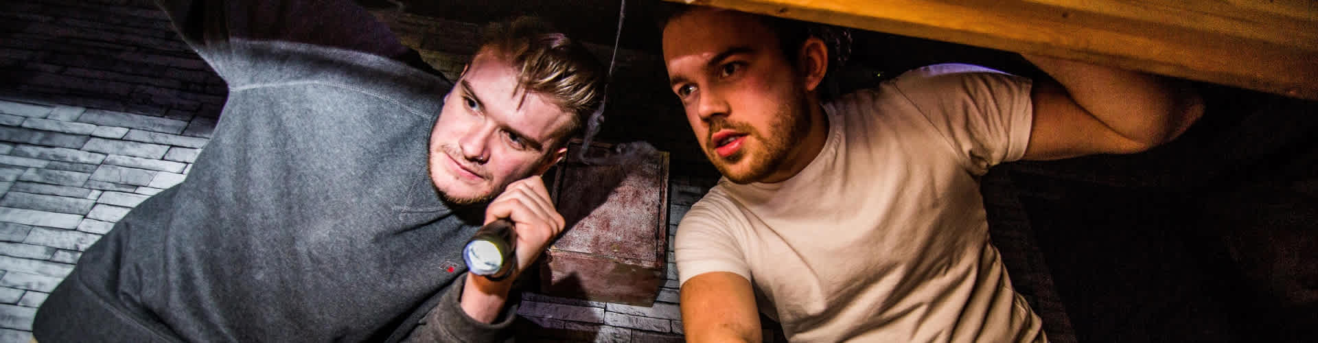 2 men looking for clues with a torch