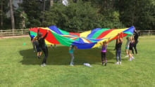 Kids with rainbow play parachute at Northampton Trampoline Centre