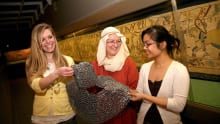 Women feeling chain mail at Reading Museum