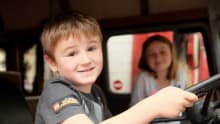 Boy behind the steering of a vehicle at the National Emergency Services Museum