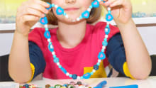 Girl making beaded necklace at Cafe Craft in Bearwood