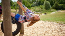 Girl on swing in playground at Great Notley Discovery Centre and Park in Braintree