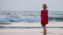 Girl standing on a sandy beach 