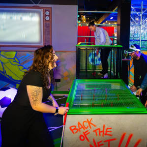 group playing foos-ball in a neon room